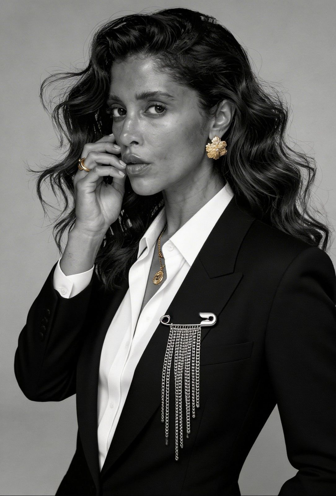 Modern brooch styled on blazer with layered jewelry, combining gold and silver pieces in a bold and contemporary look.