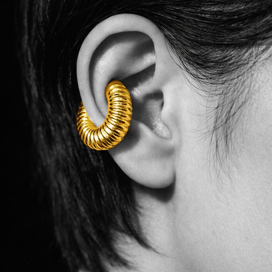 Modelo a usar earcuff dourado escultural Octavia em styling minimal urbano.