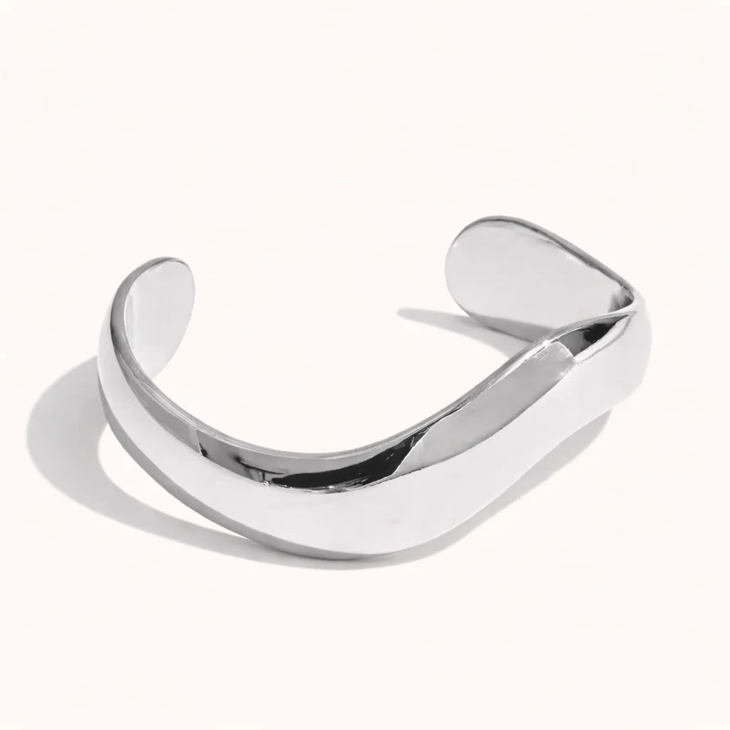 Pulseira rígida em aço inoxidável com acabamento polido espelhado disponível em dourado e prateado.