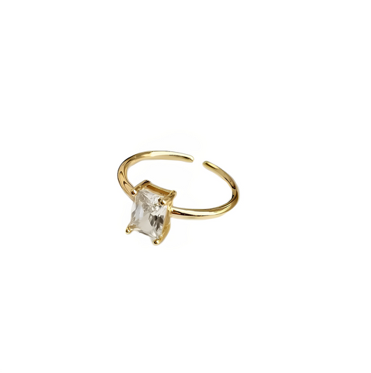 Anel Rock Me dourado com pedra central transparente, design minimalista e ajustável.